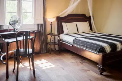 a bedroom with a bed and a desk with a fan at Romantisches Fischerhaus am Meer, 200 m vom Strand, Barcelona in Premiá de Mar