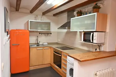a kitchen with an orange refrigerator and a sink at Homenfun Barcelona Poblenou in Barcelona