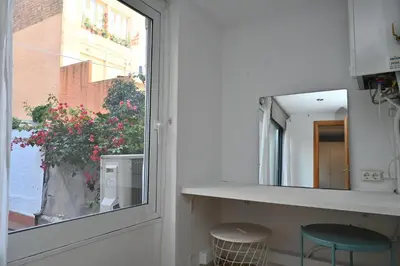 a kitchen with a window and a counter and stools at Homenfun Barcelona Poblenou in Barcelona