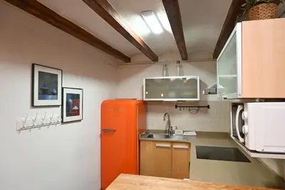 a kitchen with an orange refrigerator and a sink at Homenfun Barcelona Poblenou in Barcelona