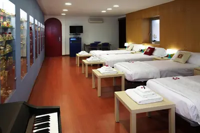 a room with four beds and a piano in it at Apartamento Granollers in Granollers