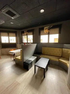 a waiting room with couches and tables and windows at Hotel Sant Celoni in San Celoni