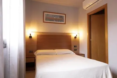 a bedroom with a white bed with a wooden headboard at Hotel Sant Celoni in San Celoni