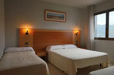 a hotel room with two beds and a window at Hotel Sant Celoni in San Celoni