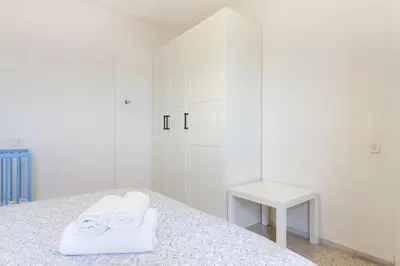 a white bedroom with two towels on a bed at Pubone AT Sabadell in Sabadell