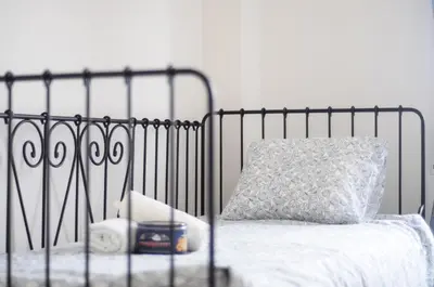 a black metal bed with a pillow on it at Pubone AT Sabadell in Sabadell