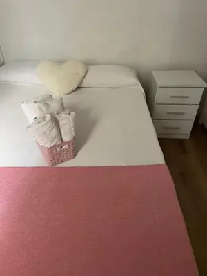 a bedroom with a bed with a basket of towels at Alojamiento muy cómodo in Hospitalet de Llobregat