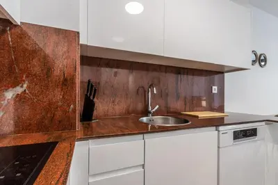 a kitchen with white cabinets and a sink at Macu in Sabadell