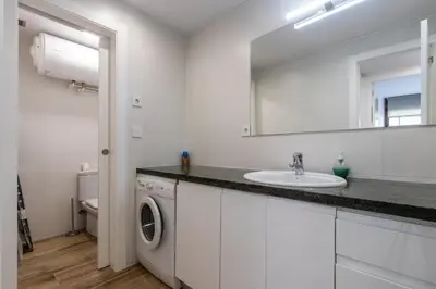 a bathroom with a sink and a washing machine at Macu in Sabadell