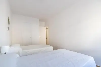 two beds in a bedroom with white walls at Macu in Sabadell