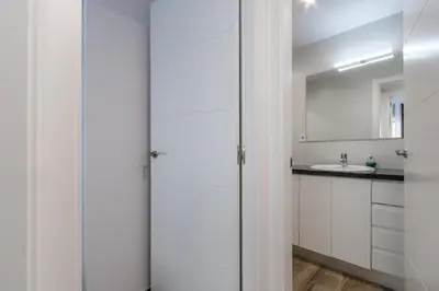 a white bathroom with a sink and a mirror at Macu in Sabadell