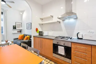 a kitchen with a stove and a table in a room at Progres in Barcelona