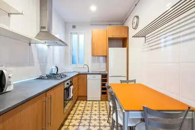 a kitchen with an orange table in a kitchen at Progres in Barcelona