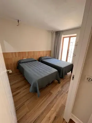 two beds in a room with wooden floors at The Nest Masia Can Tiranasi Relájate y Disfruta Escapada con Encanto Cerca de Barcelona- in Badalona