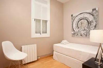 a living room with a table and white chairs at Gran Via modern and bright 3BD with terrace in Barcelona