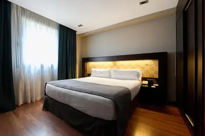 a bedroom with a large bed and a window at Catalonia Port in Barcelona