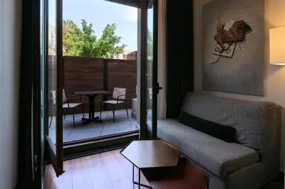 a living room with a couch and a balcony with a table at Catalonia Port in Barcelona