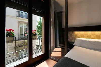 a bedroom with a balcony with a bed and a window at Catalonia Port in Barcelona