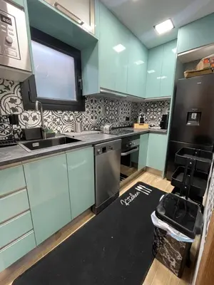 a kitchen with blue cabinets and a black counter top at Piso luxori in Santa Coloma de Gramanet