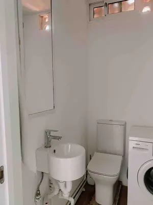 a white bathroom with a sink and a toilet at Beach apartment 2 terraces with parking in Castelldefels