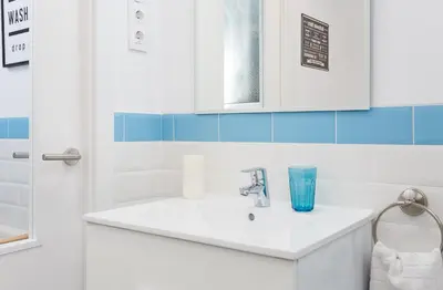 a bathroom with a sink and a blue glass at Opening Doors Sagrada Familia II in Barcelona