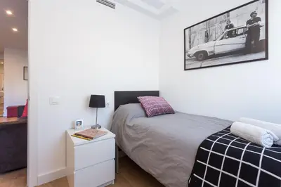 a bedroom with a bed and a picture of a car on the wall at Opening Doors Sagrada Familia II in Barcelona