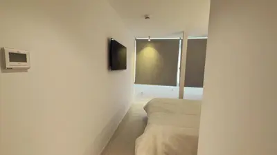 a bedroom with a bed and a tv on the wall at MYO Barcelona Hotel & Apartments in Castelldefels
