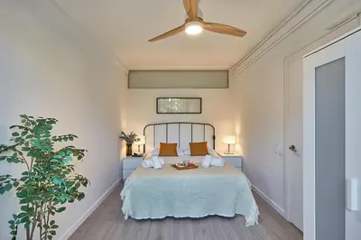 a bedroom with a bed and a ceiling fan at BBarcelona Gracia Apartment in Barcelona
