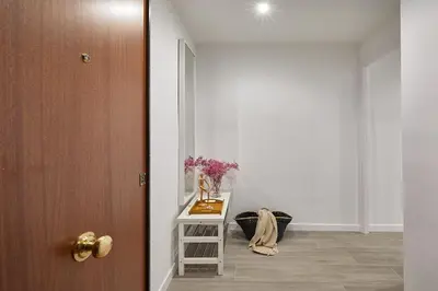 a hallway with a table with flowers and a door at BBarcelona Gracia Apartment in Barcelona