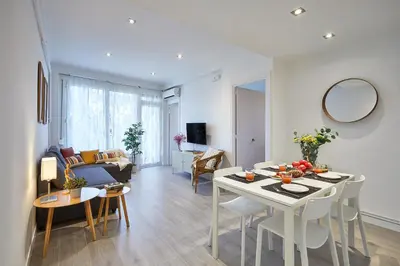 a dining room and living room with a table and chairs at BBarcelona Gracia Apartment in Barcelona