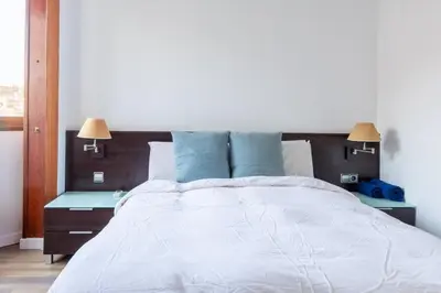a bedroom with a large white bed with blue pillows at Sagrada Familia views, big and bright apartment in Barcelona