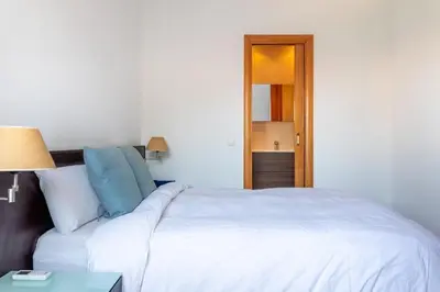 a bedroom with a large white bed and a table at Sagrada Familia views, big and bright apartment in Barcelona