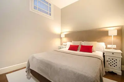 a bedroom with a large bed with two red pillows at Three bedroom apartment in Gran de Gracia - You Stylish Apartments in Barcelona