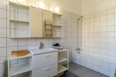 a white tiled bathroom with a sink and a tub at 4305 - AB Eixample Sepúlveda 157 in Barcelona