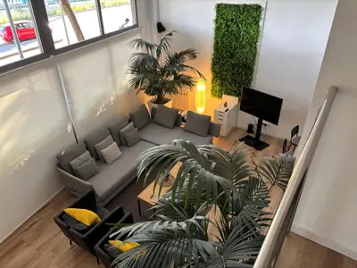 a living room with a couch and a plant at Apartment close Barcelona - Rentals Badalona Beach - Free Parking in Badalona
