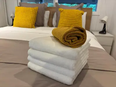 a pile of towels sitting on top of a bed at Apartment close Barcelona - Rentals Badalona Beach - Free Parking in Badalona