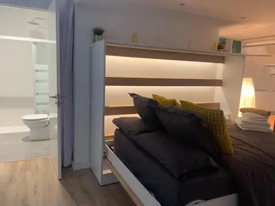 a bedroom with a bed with a wooden headboard at Apartment close Barcelona - Rentals Badalona Beach - Free Parking in Badalona