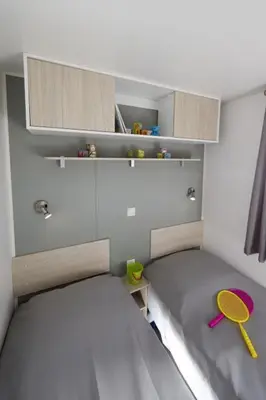 a small room with a bed and a tennis racket at Camping Victoria in Canet de Mar
