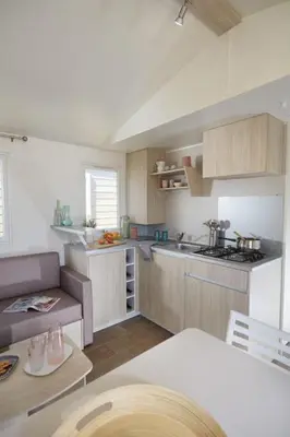 a small kitchen with a table and a kitchen with a counter at Camping Victoria in Canet de Mar