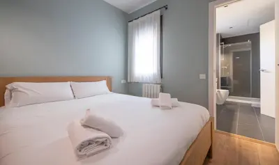a bedroom with a white bed with towels on it at Central One bedroom apartment You Stylish Apartments in Barcelona