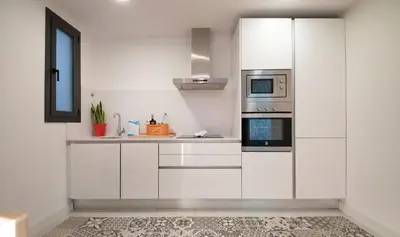 a white kitchen with white cabinets and a microwave at Central One bedroom apartment You Stylish Apartments in Barcelona