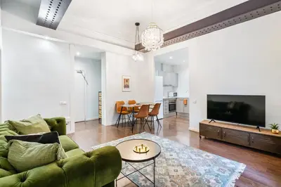 a living room with a green couch and a table at Muntaner in Barcelona