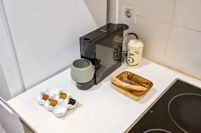 a kitchen counter with a coffee maker and a box of cigarettes at Muntaner in Barcelona