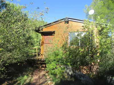 a small wooden building with a bridge in front of it at Climbers Cabin in Marganell
