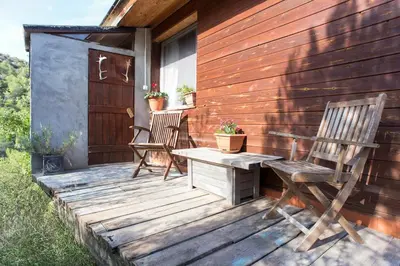 two chairs and a table on a wooden deck at Climbers Cabin in Marganell