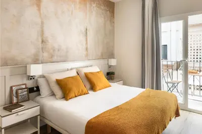 a bedroom with a large white bed with yellow pillows at Rainbow Sitges in Sitges