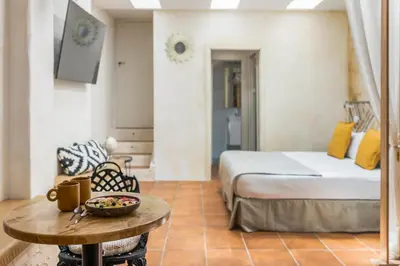 a bedroom with a bed and a table with a bowl on it at Rainbow Sitges in Sitges