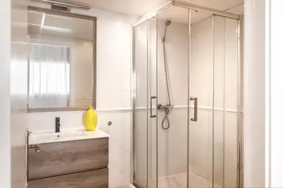 a shower with a glass door next to a sink at Rainbow Sitges in Sitges