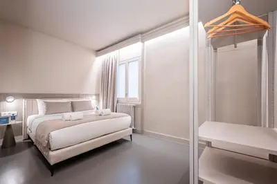 a white bedroom with a bed and a window at Sweett - Gaudi Avenue in Barcelona