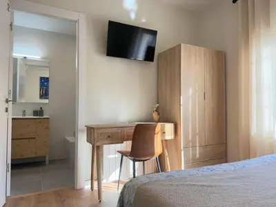 a bedroom with a desk with a chair and a bed at Villa Leonardo in Castelldefels